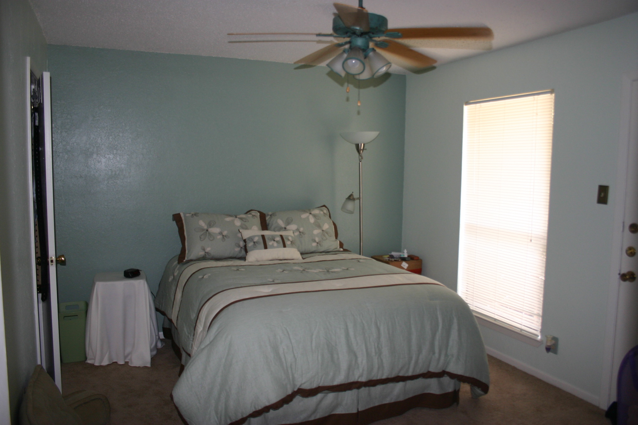 this bedroom has a large bed and a ceiling fan