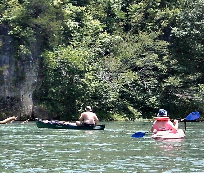 a couple paddling their canoes in a river