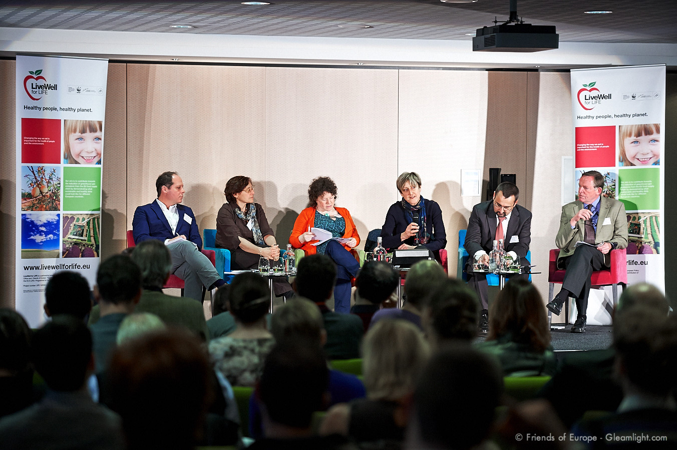 people sitting in chairs during a panel on public issues