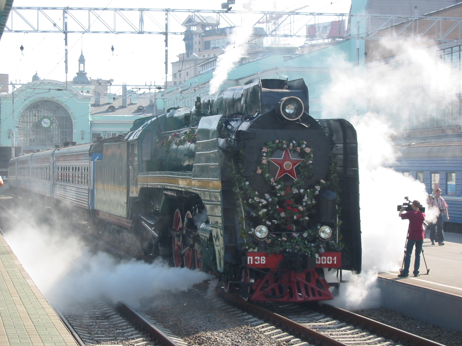 a black train traveling past a train station