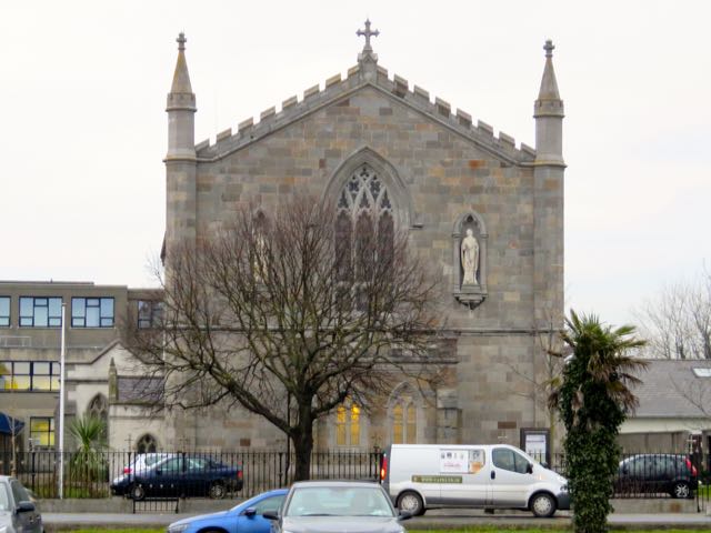 an old church is seen on the corner of a road
