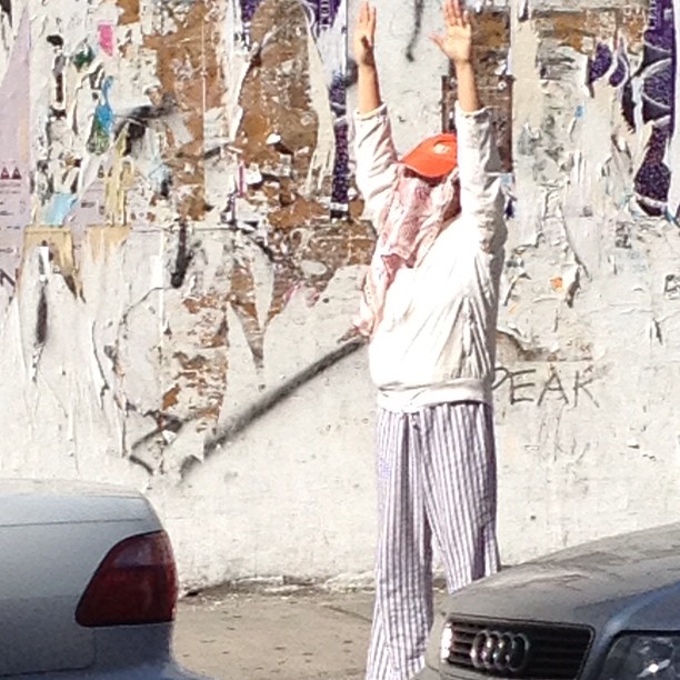 a man on the street reaching up into the air