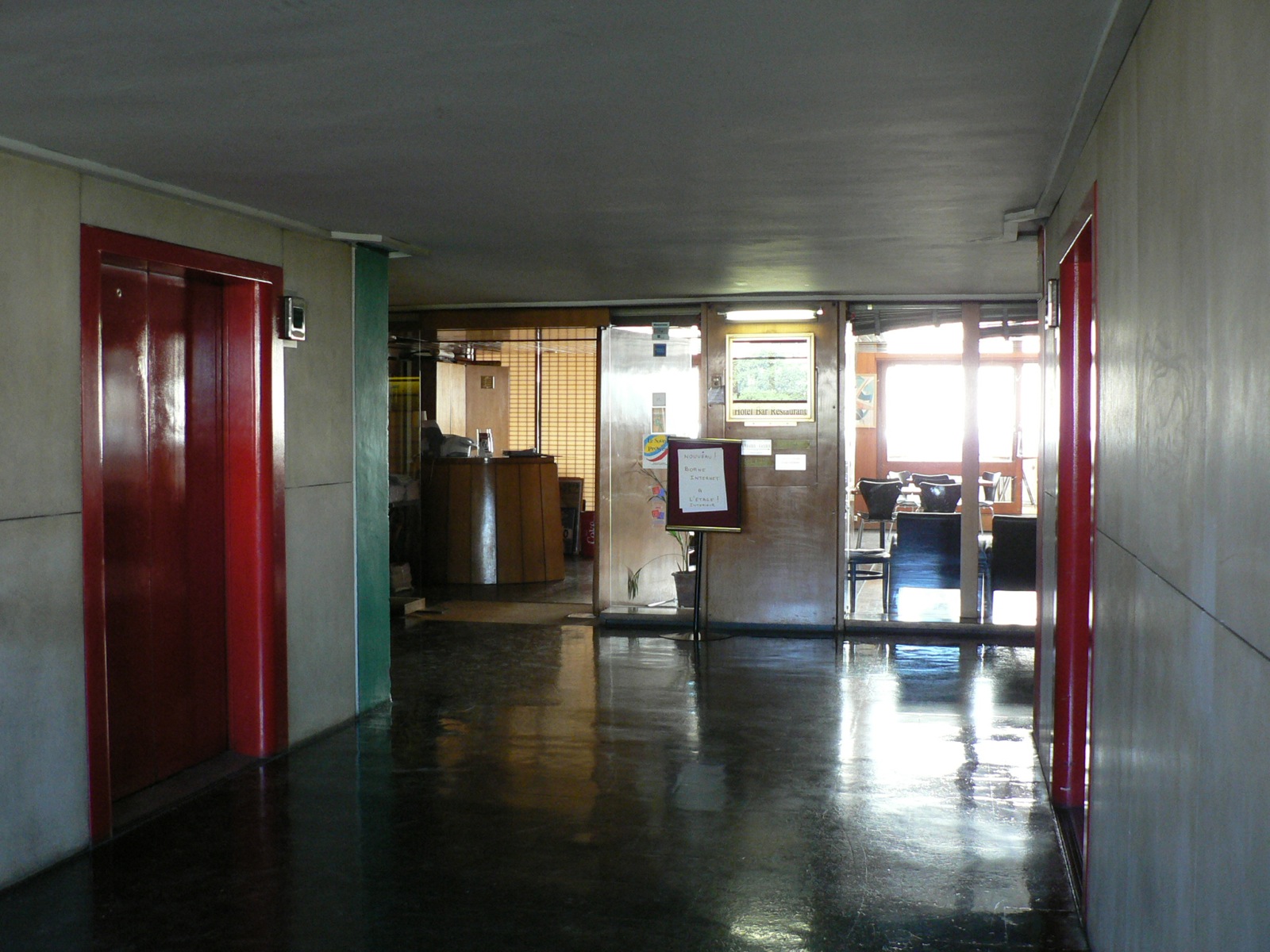 the hallway leads to the room where there is a counter and refrigerator