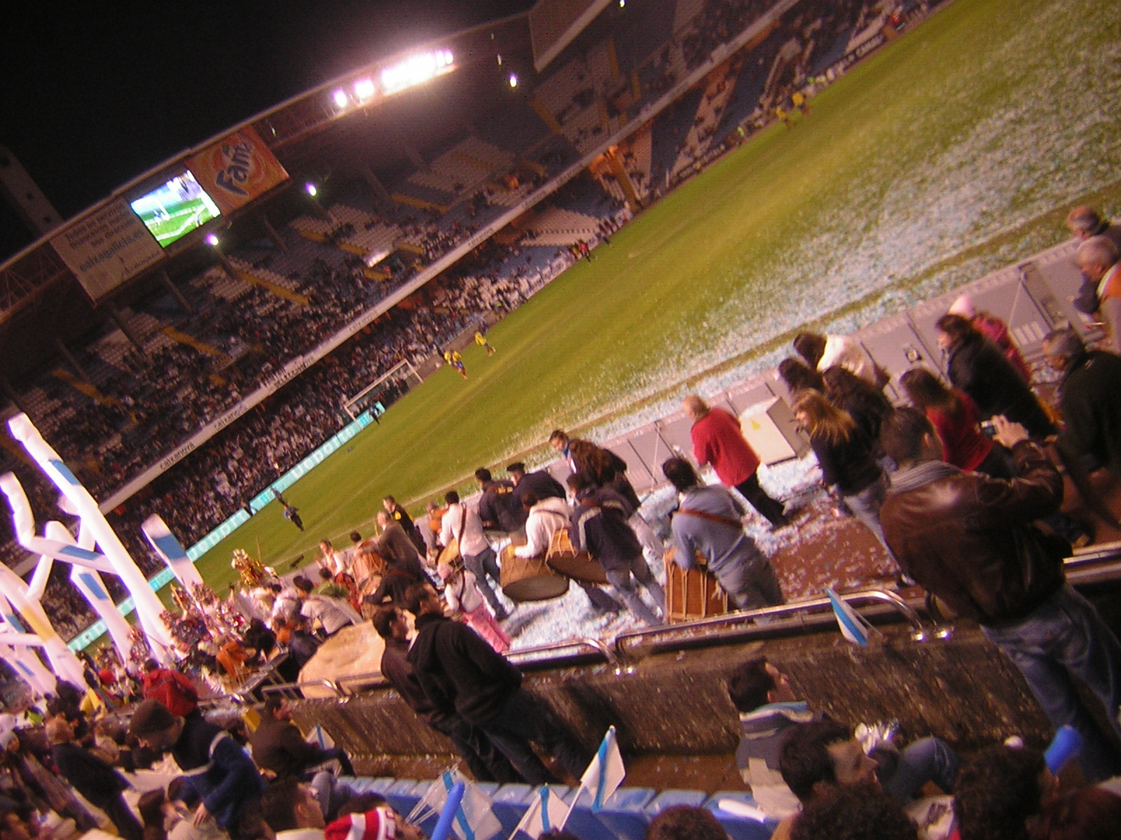 people in the stands in a stadium at night