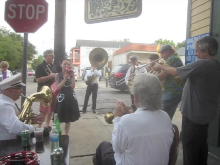 people are gathered outside of a restaurant on the street to enjoy music