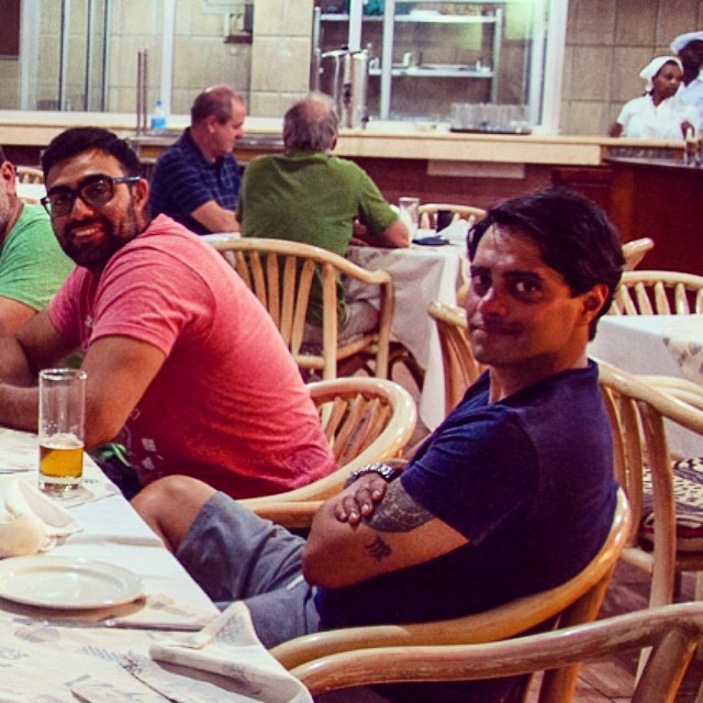 a group of men are sitting down at a table with drinks