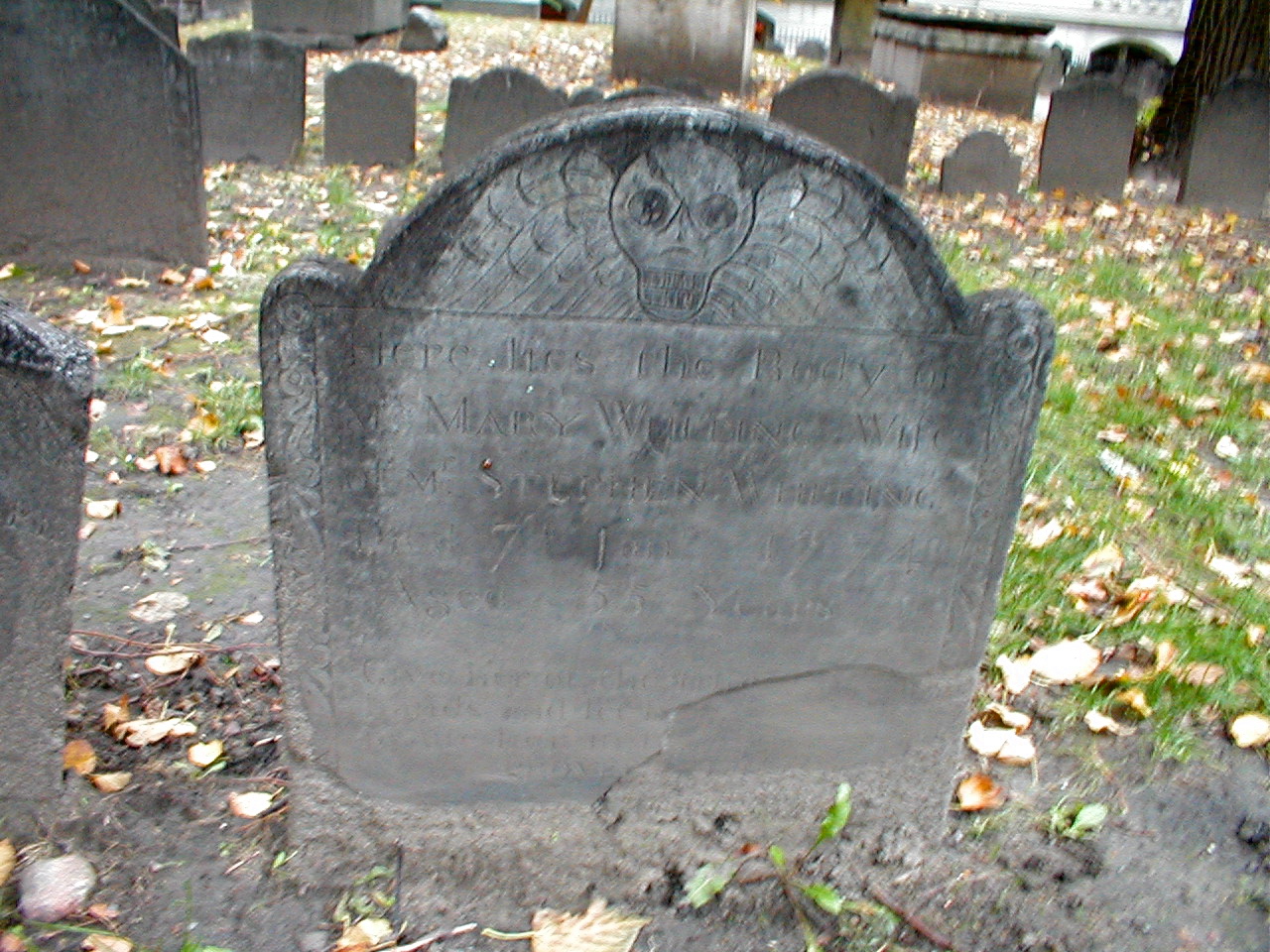 an old headstone stands in the grave yard