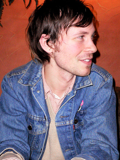 a man with blue denim jacket sitting on couch