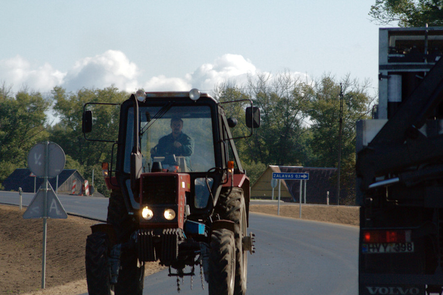 a man driving a tractor on a rural road