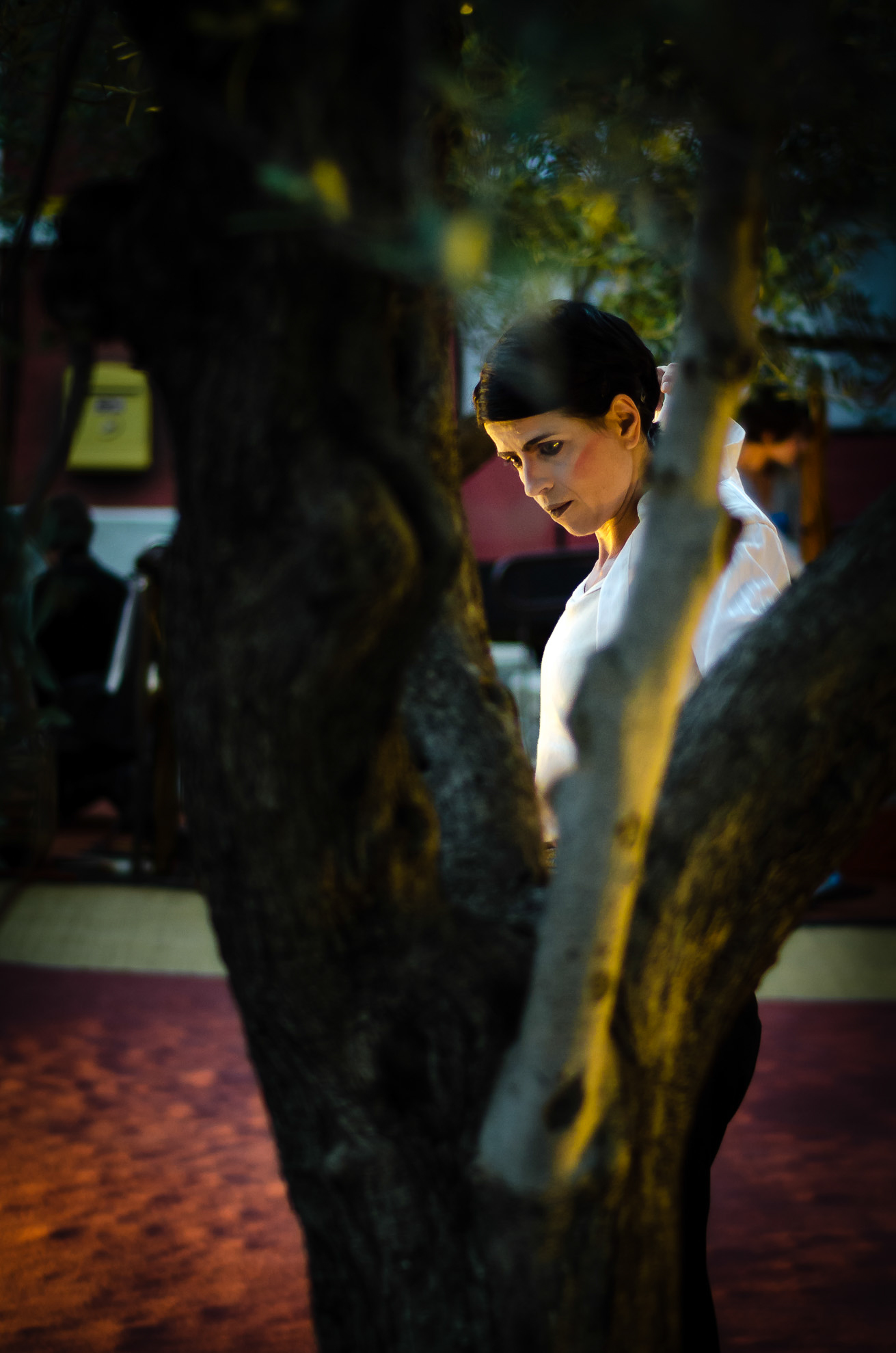 a woman is standing under the shade of a tree