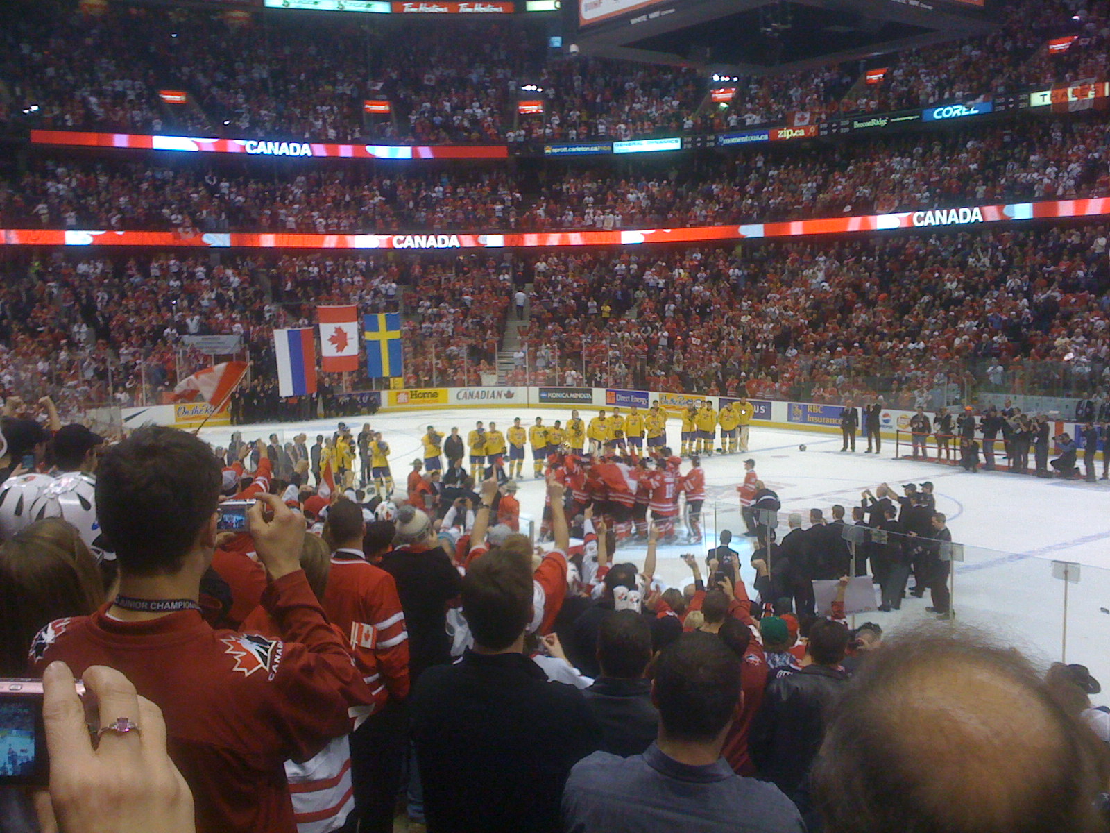 the hockey rink is full of spectators watching a match