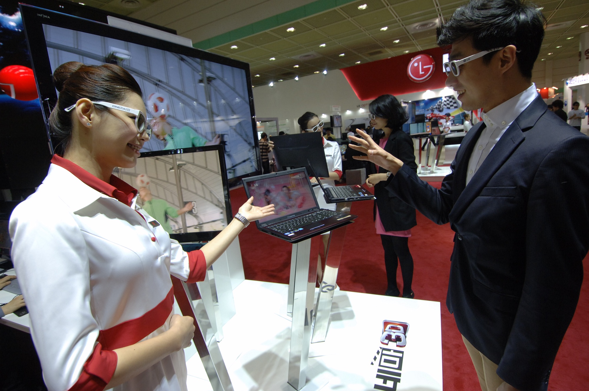 a man and woman holding a laptop at a trade event