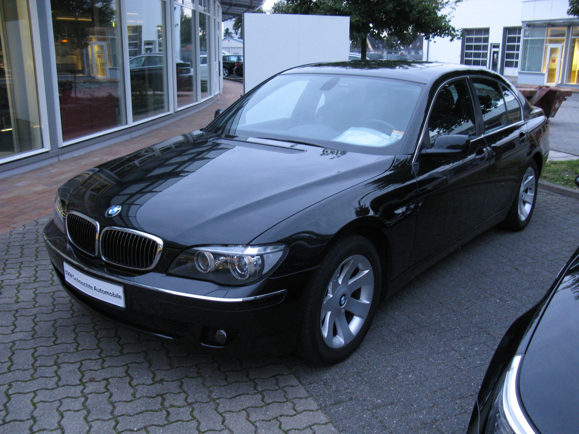 a parked bmw car and other vehicles sitting in front of building