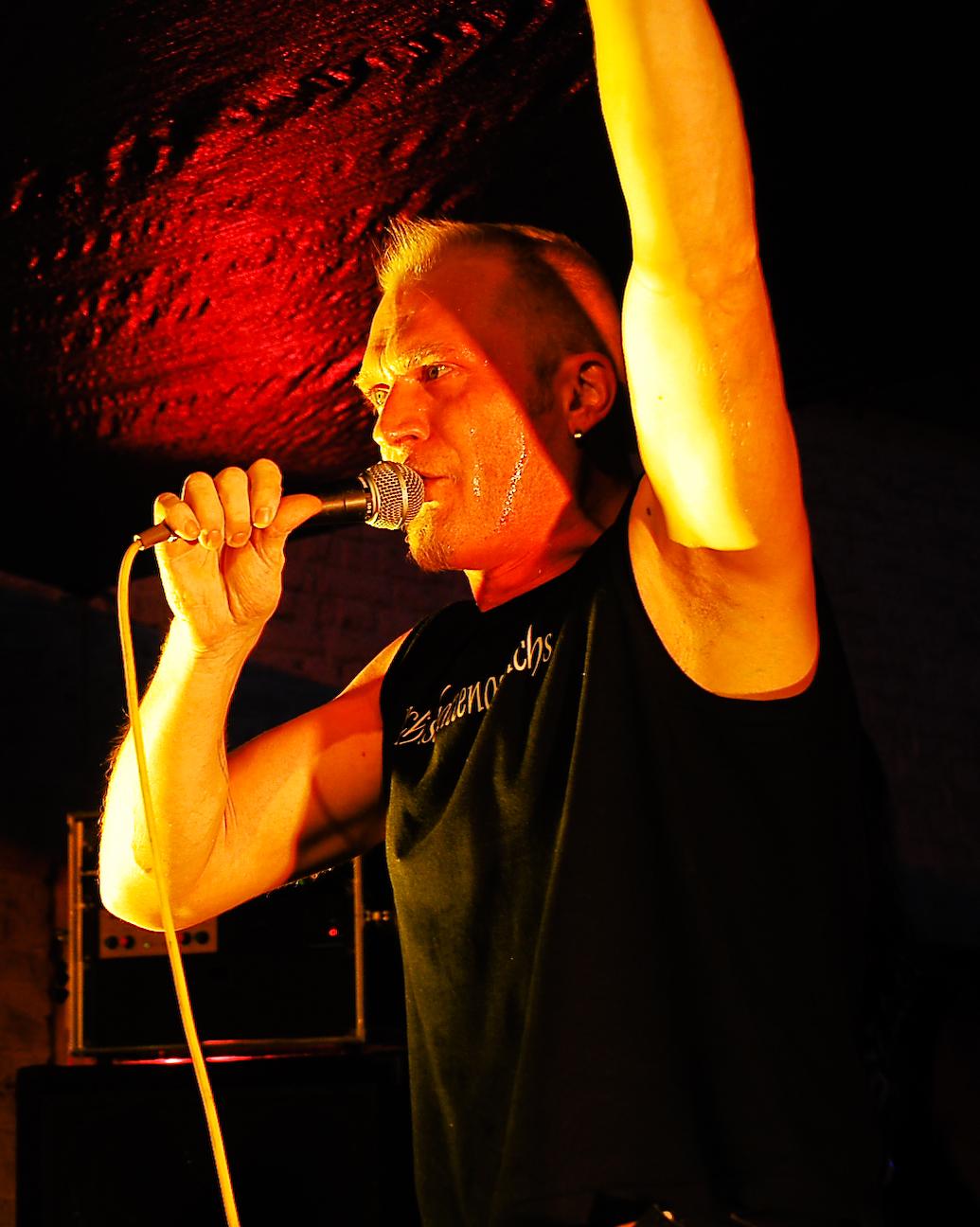 a man standing on stage with his arm in the air