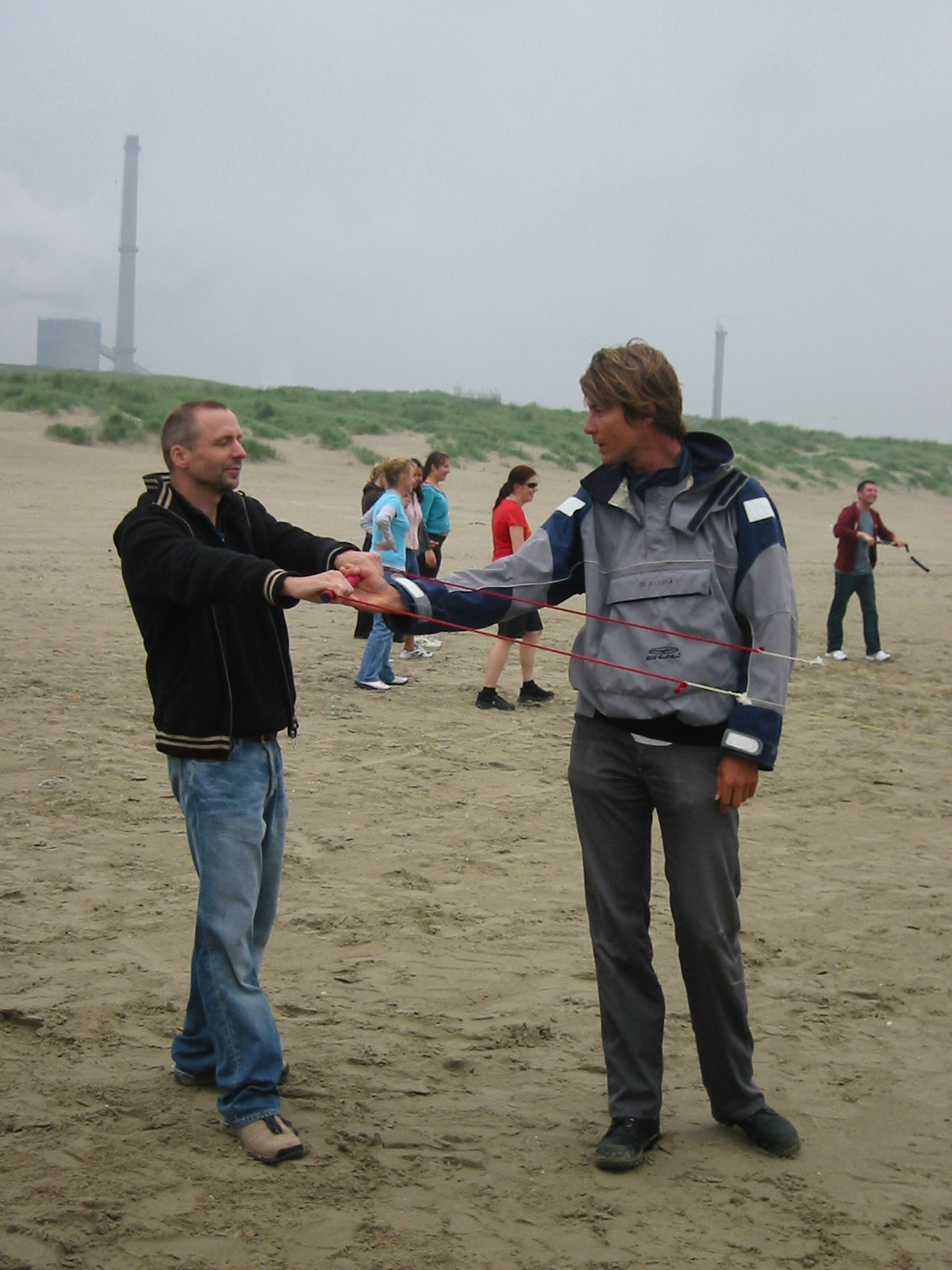 man in grey jacket handing another man soing