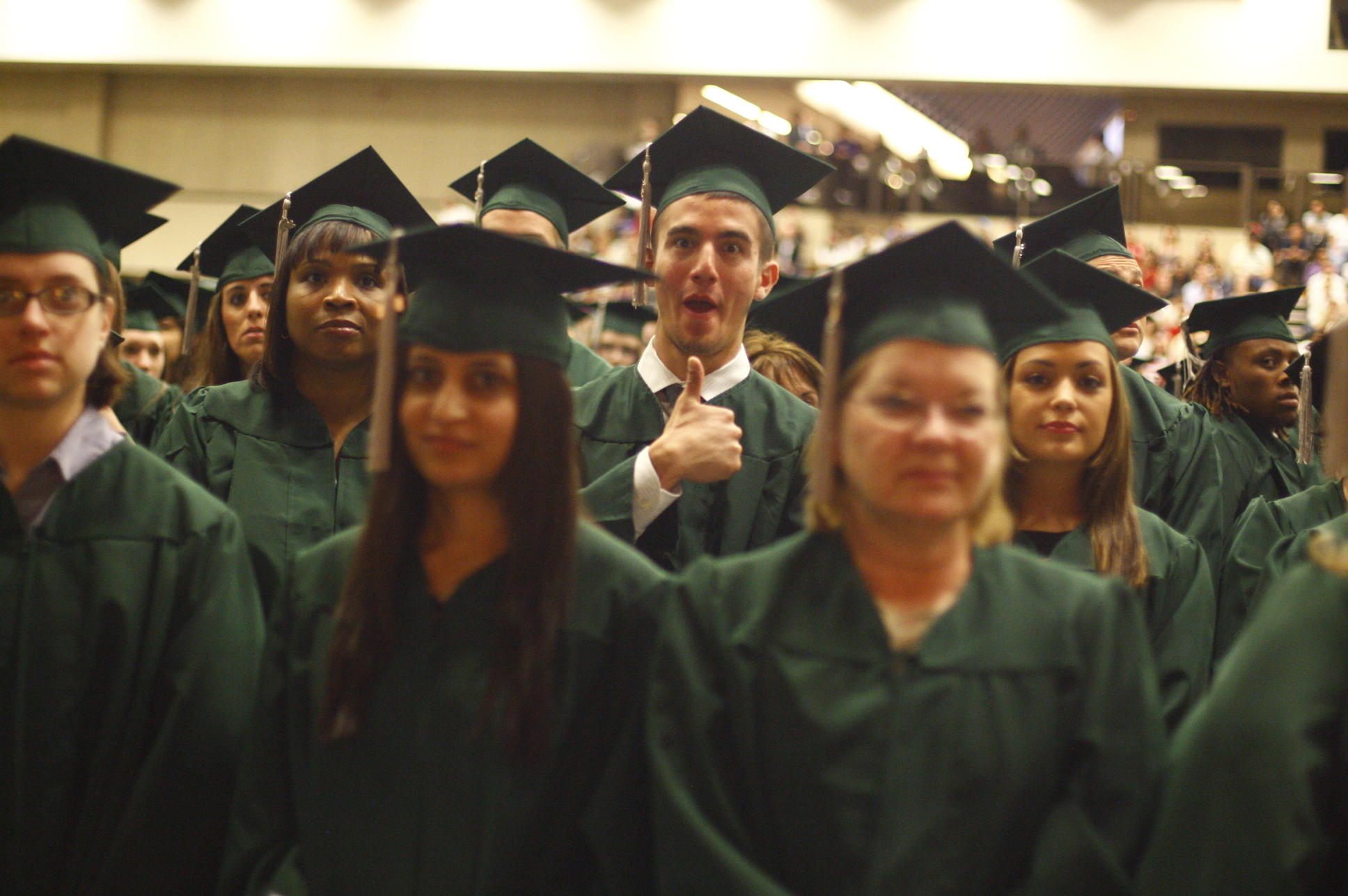 an image of graduates in green graduation gowns