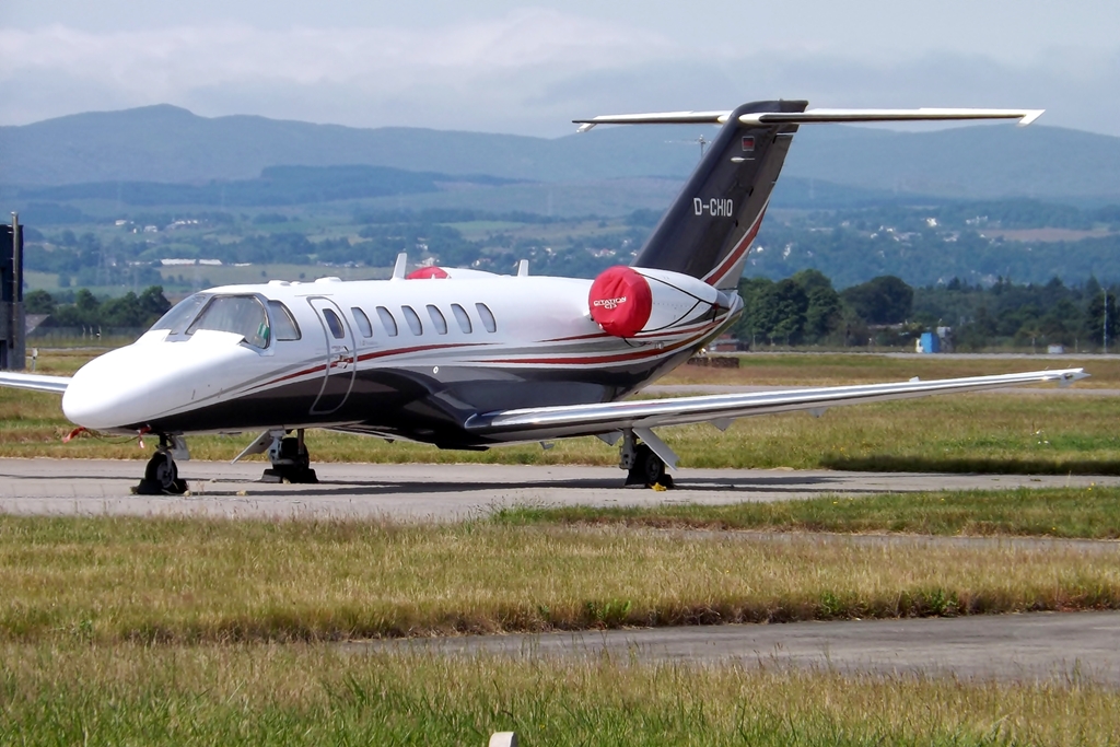 small private jet on runway at airport with mountains in background