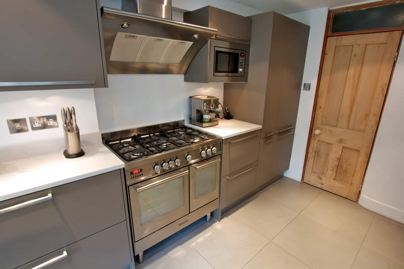 a kitchen that is painted silver and has stainless steel appliances