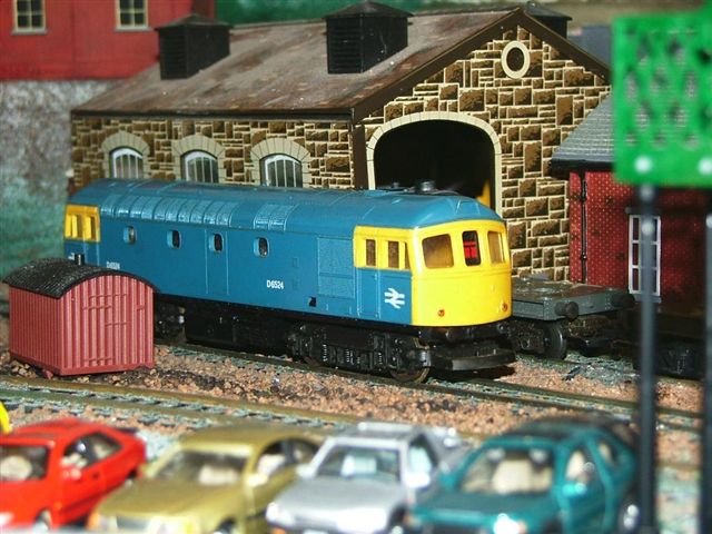 some cars and trains on a model track