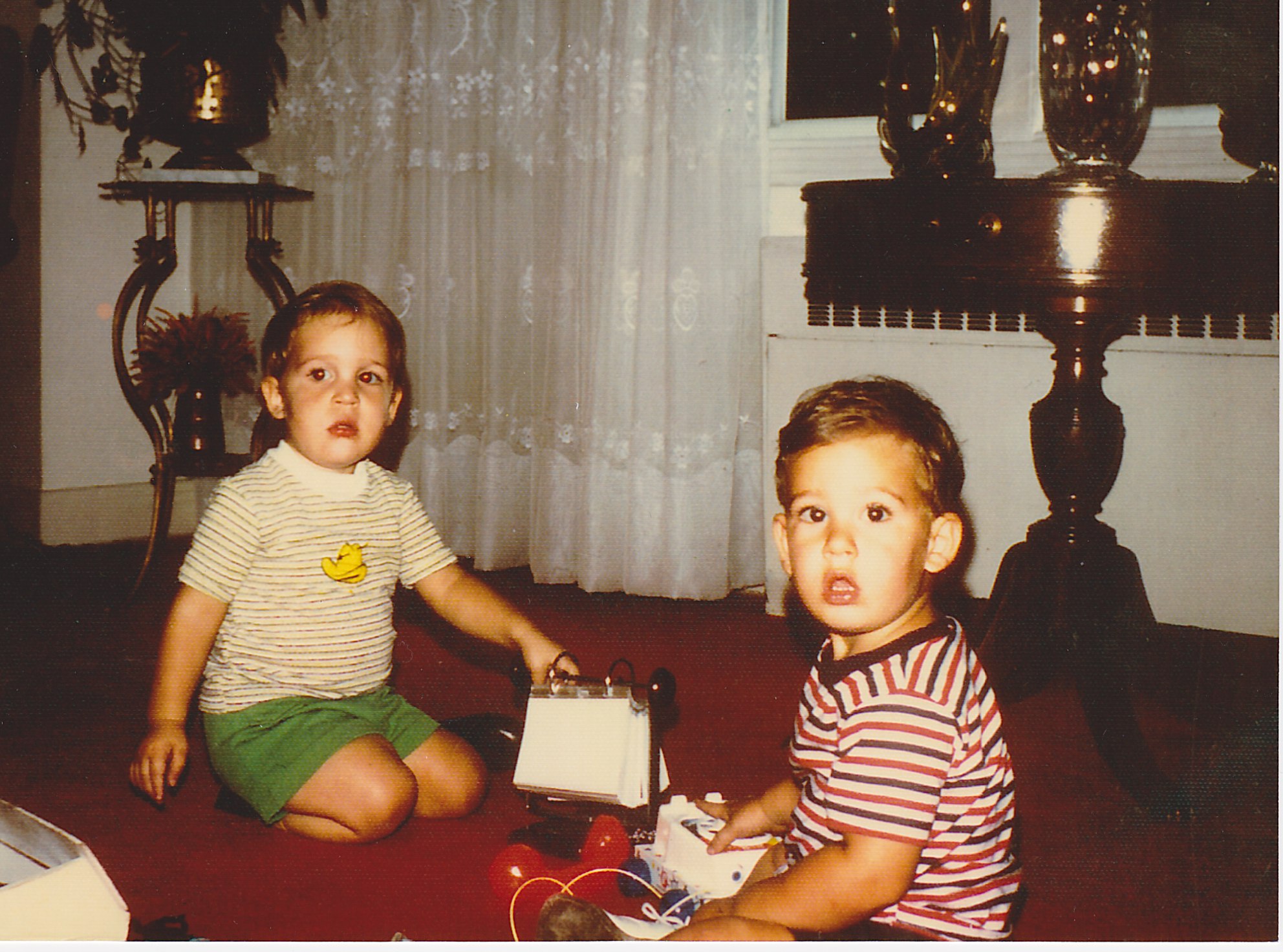 two children playing with toy car on the floor