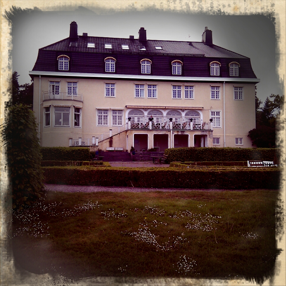 large building with two balconies and some bushes