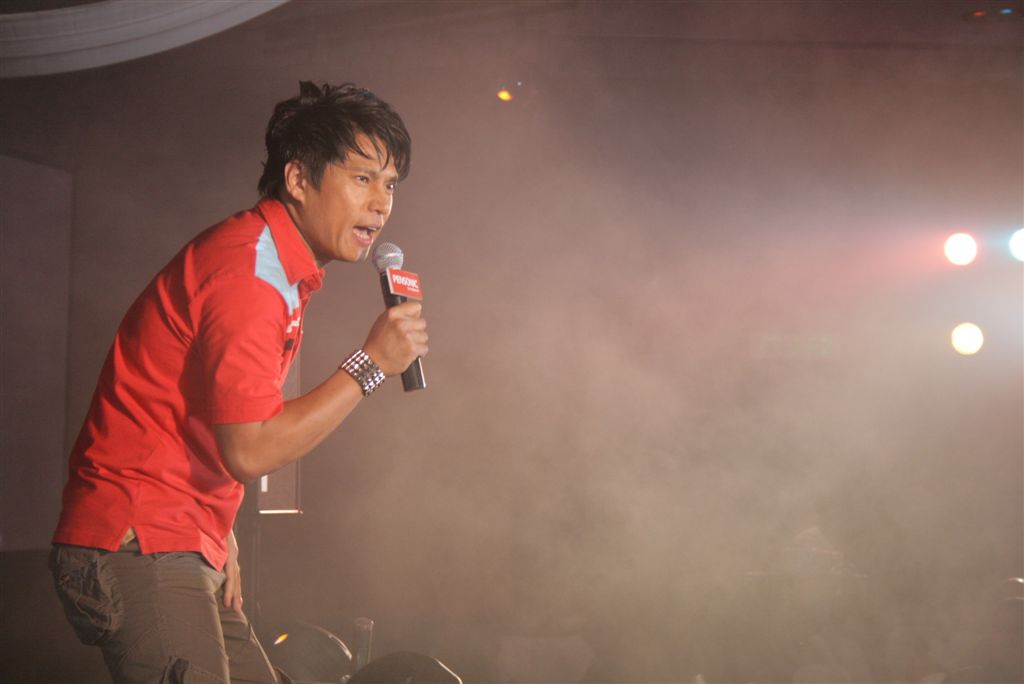an asian man is speaking into a microphone