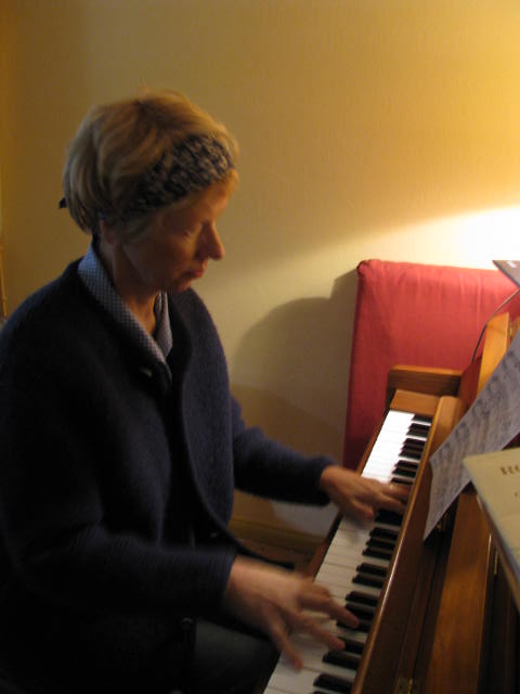 a woman playing a piano with sheets on the ground