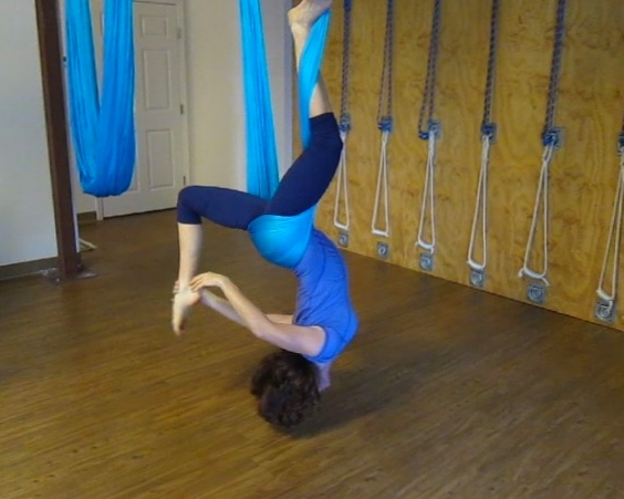 a woman is doing aerial yoga exercises on the floor