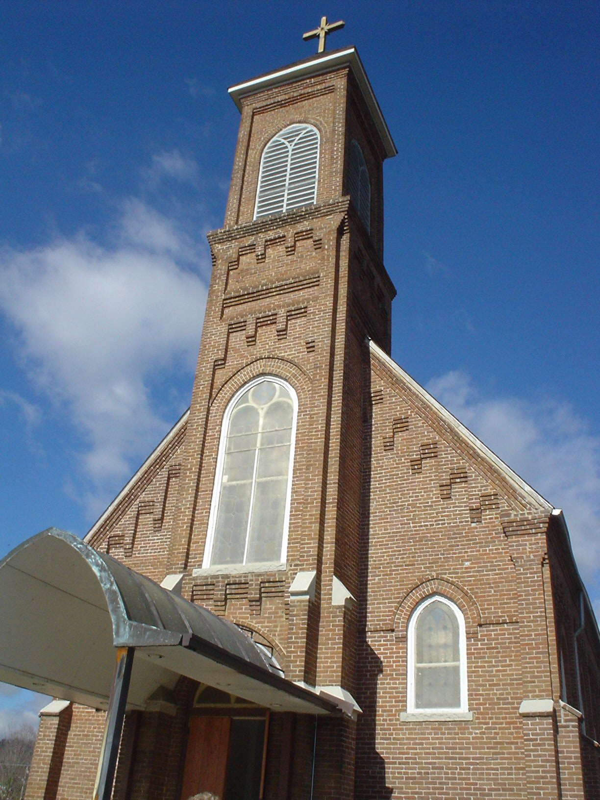an old church with a steeple under a blue sky