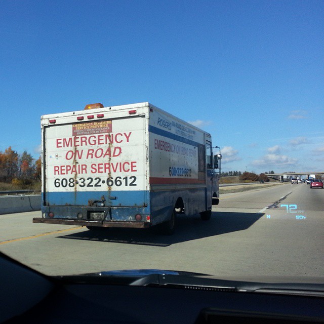 a moving truck drives down a highway next to a bridge