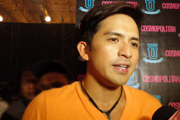 young man in orange shirt talking into microphone