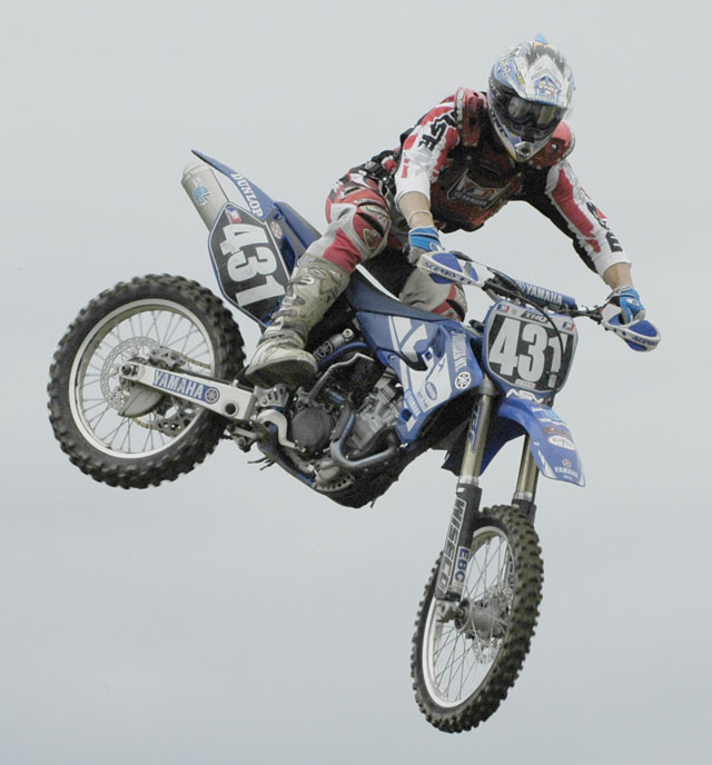 a man in the air on a motorcycle on some concrete