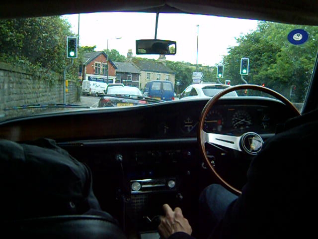 view from a passenger's seat of a street and a man in the driver seat