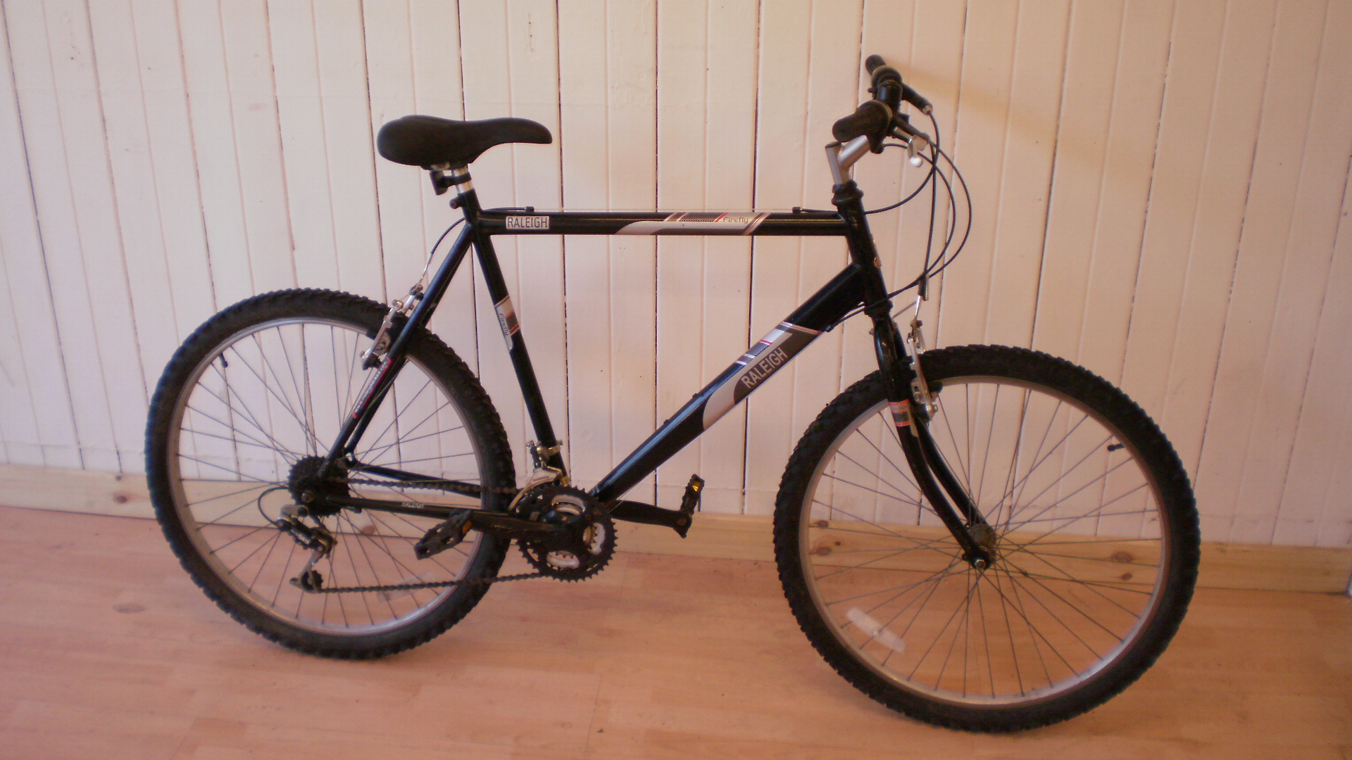 a black bike is propped up against the wall