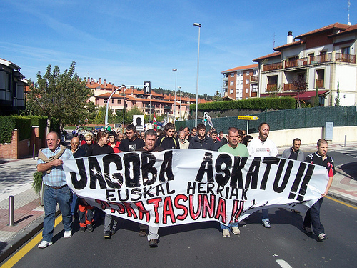 a group of people in front of a building holding up a banner