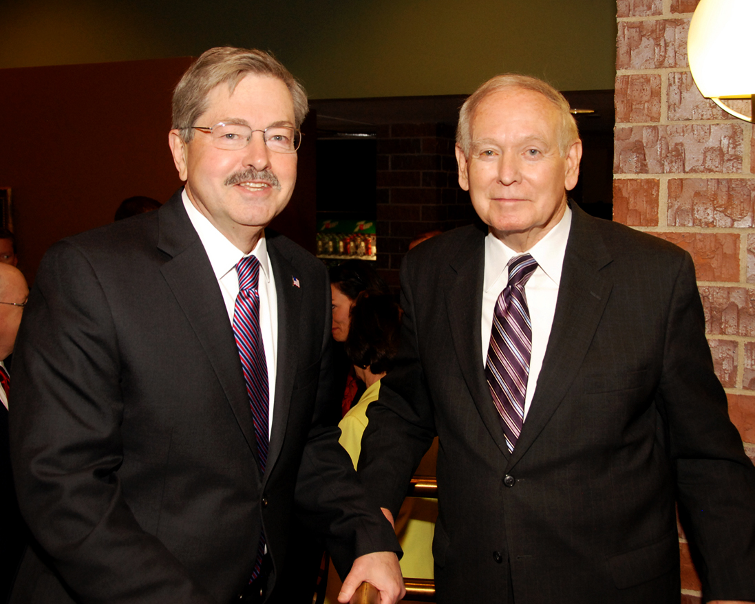 two men in suits and ties are standing together