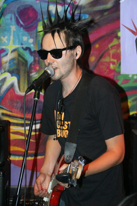 a man is playing a guitar in front of a microphone