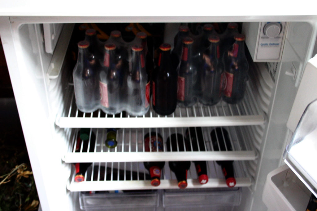 a refrigerator with its doors open revealing several bottles of beer