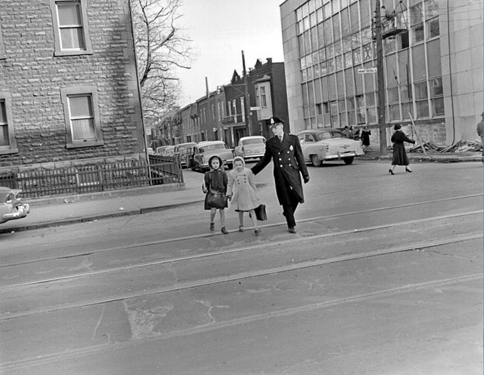 a man and three little girls walking down a street