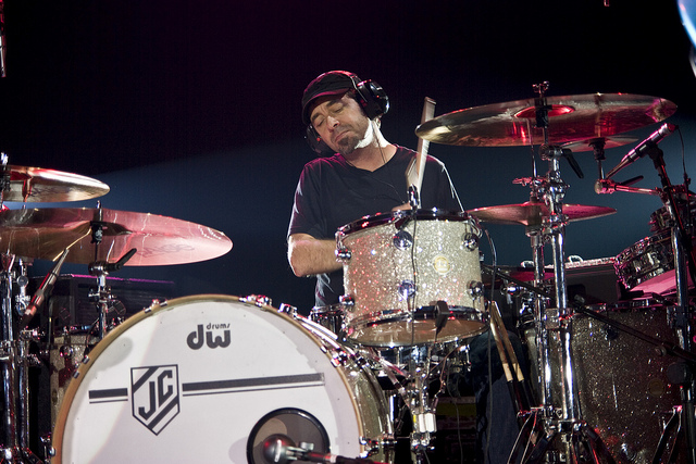 a drummer with headphones on behind a drum set