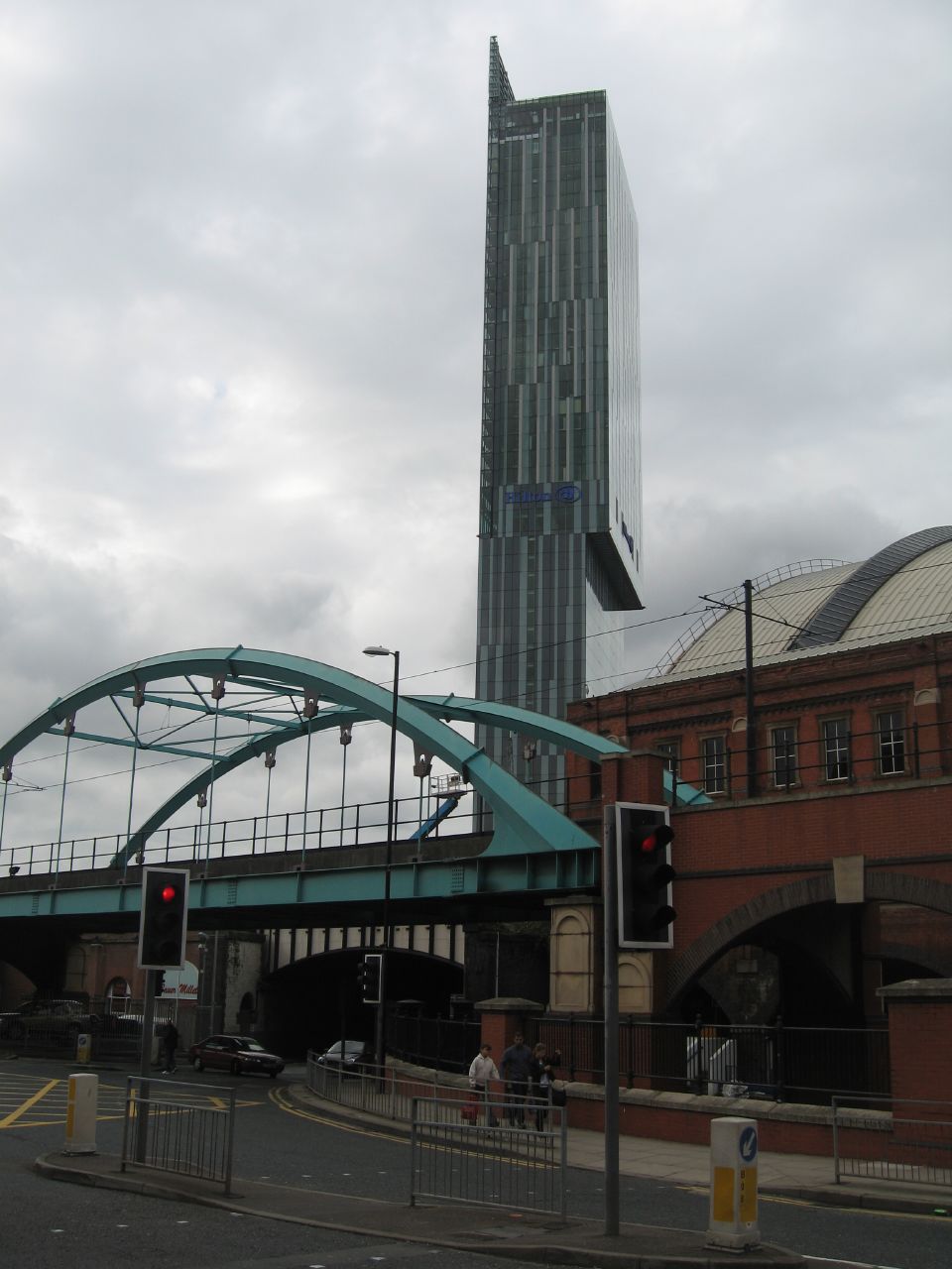 a tall building sitting next to a bridge with a traffic light