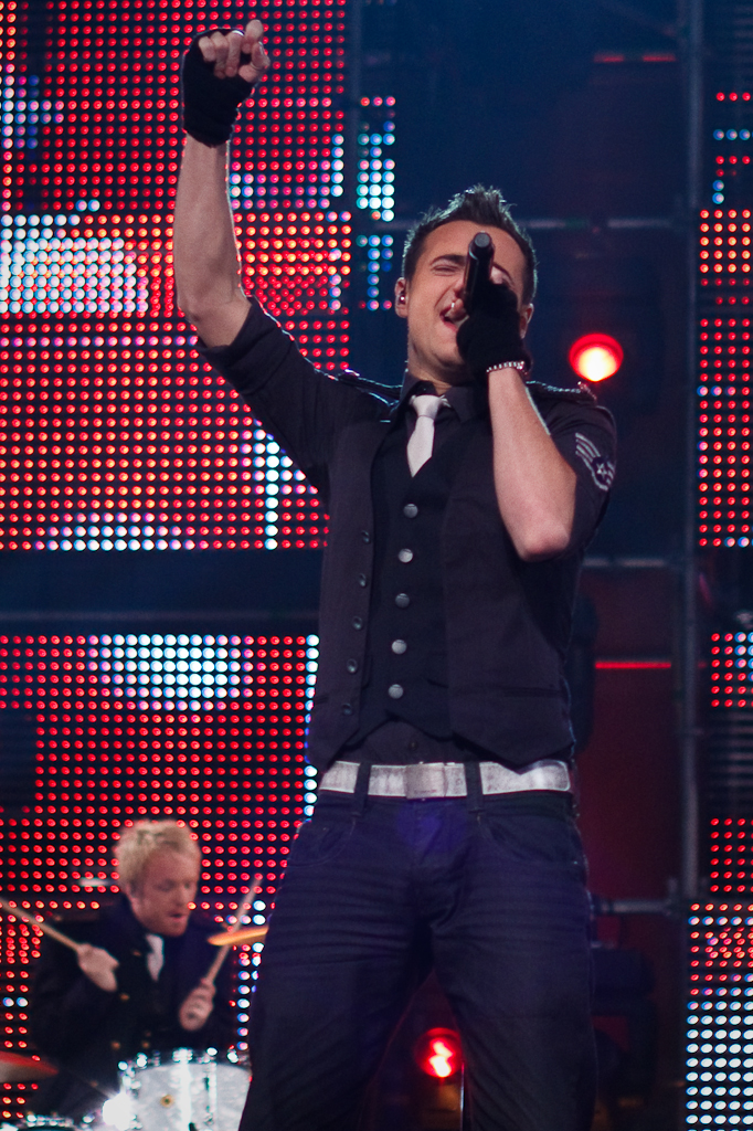 a man wearing a vest and glove at a concert