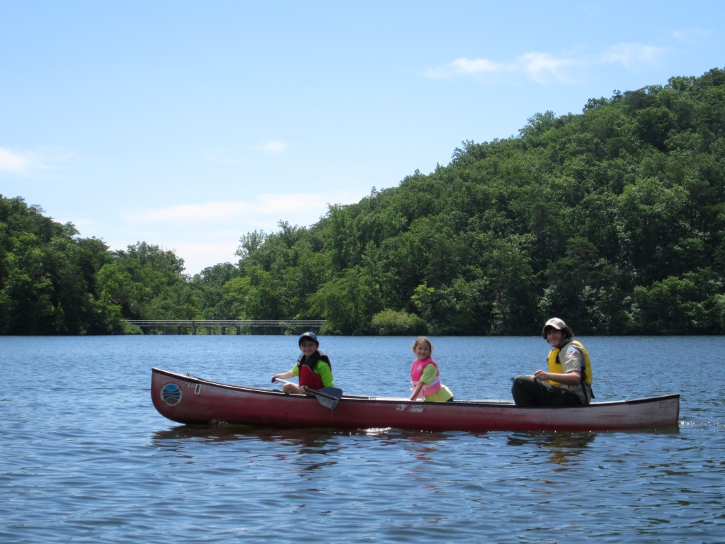 three people in a canoe on a lake