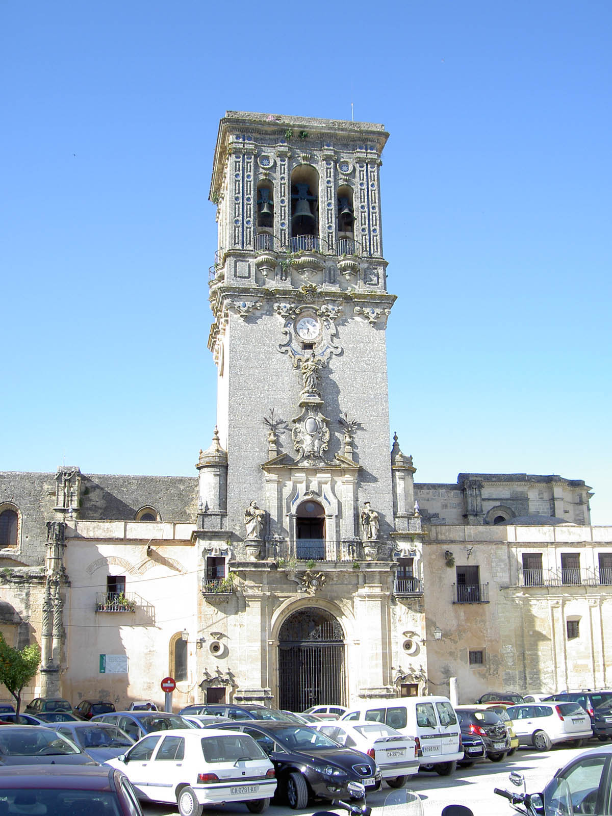 this is a church tower surrounded by many cars