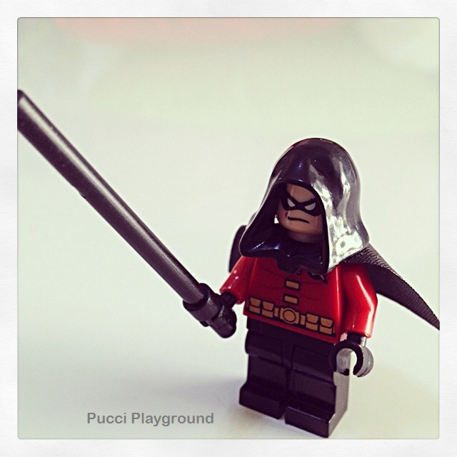 the lego batman is holding onto a black sword