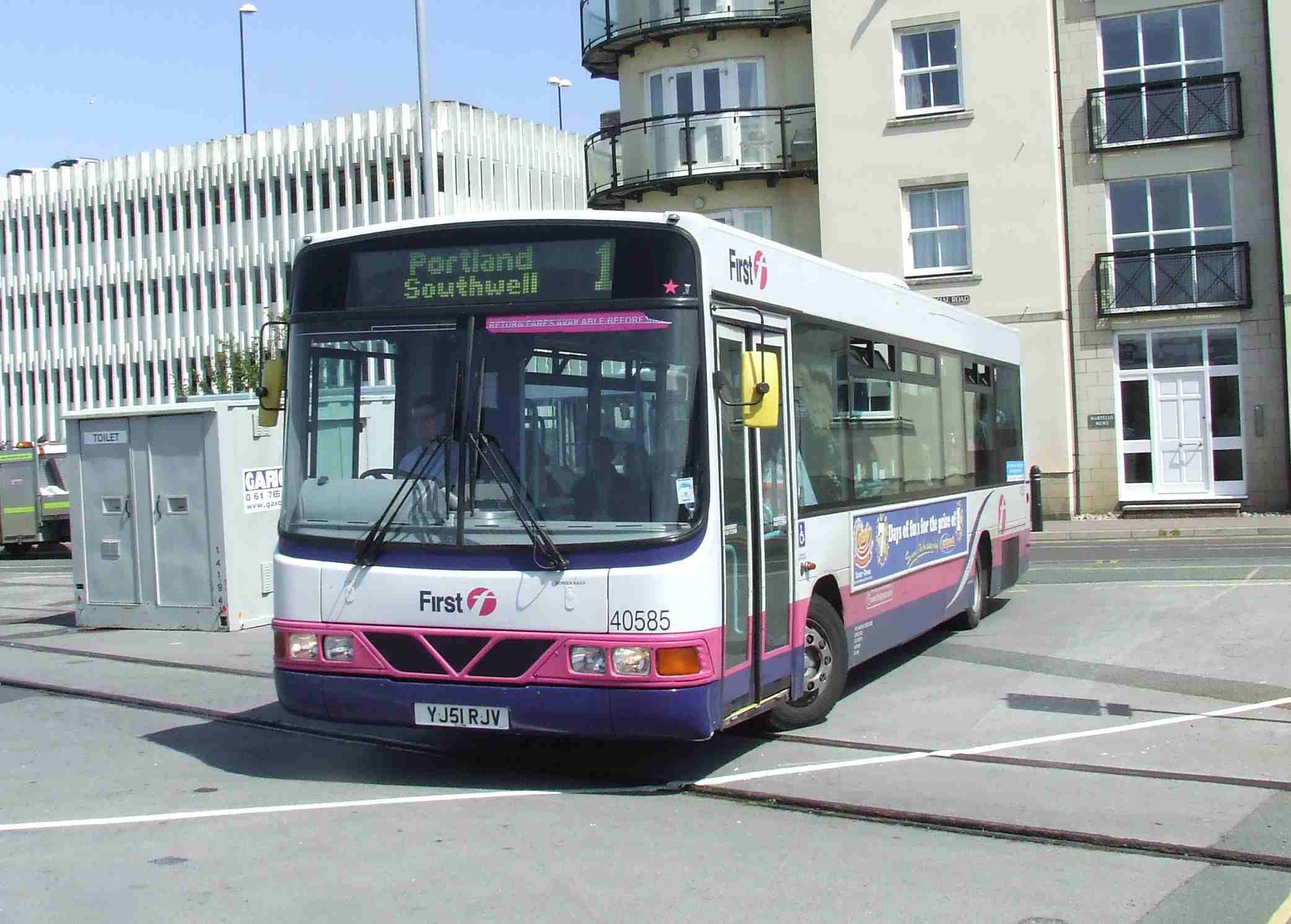 a city bus turning onto the street in front of a building