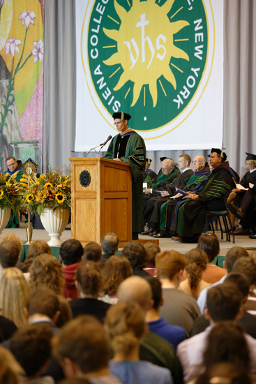 a man is giving a graduation speech at a ceremony