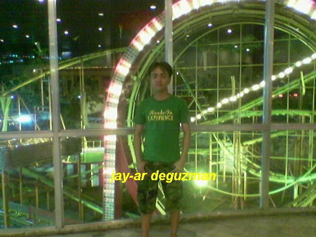 boy in front of the roller coaster at night