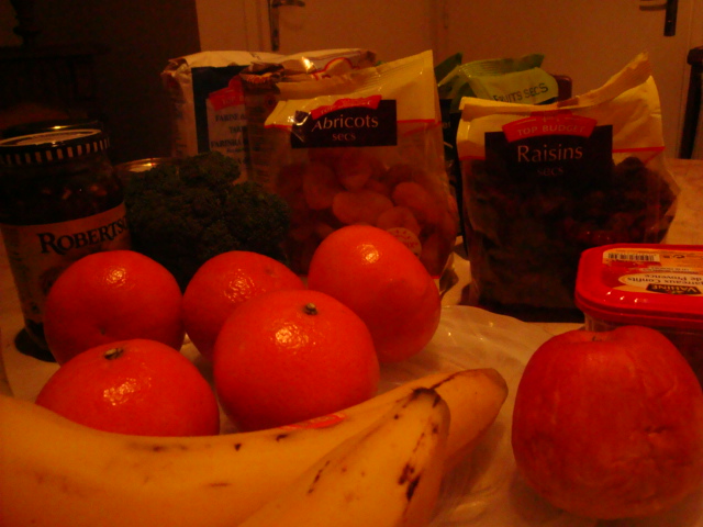 a table topped with fruit and vegetables next to packages of chips