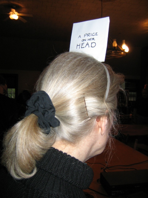 a lady with long blonde hair has her head pinned to a piece of paper
